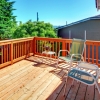 Large new wood deck home exterior with chairs.